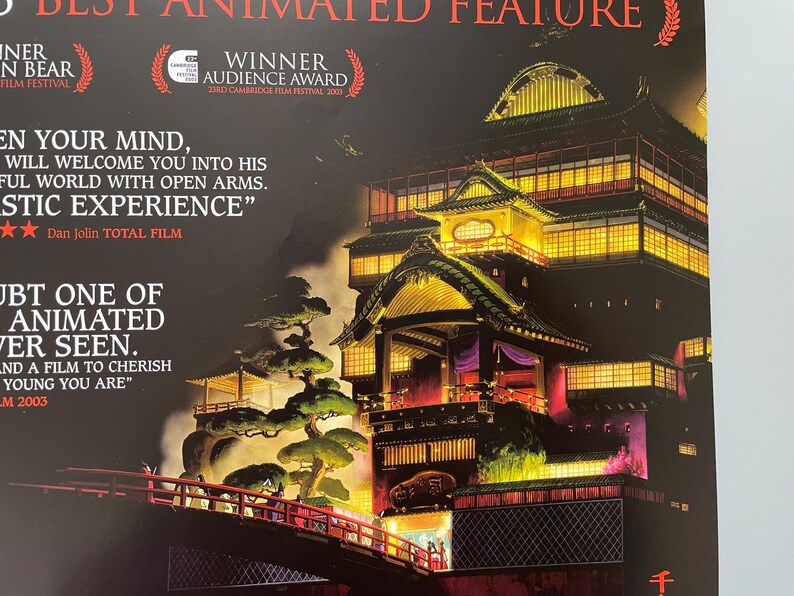 May include: Poster for an animated film featuring a detailed illustration of a traditional Japanese building with illuminated windows and a red bridge. The poster includes text and awards.