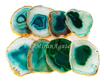 May include: Set of eight green agate coasters with gold trim. Each coaster features a unique pattern of green and white agate.