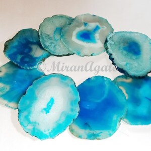 May include: A set of eight agate coasters in shades of blue and white. The coasters are round and have a natural, polished finish.