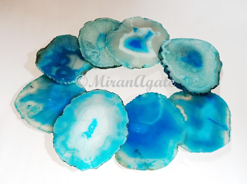 May include: A set of eight agate coasters in shades of blue and white. The coasters are round and have a natural, polished finish.