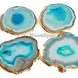 May include: Four agate coasters with gold trim. Each coaster features a unique blue and white agate pattern.