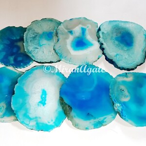 May include: Set of eight agate coasters in shades of blue and white. The coasters are round and have a natural, polished finish.