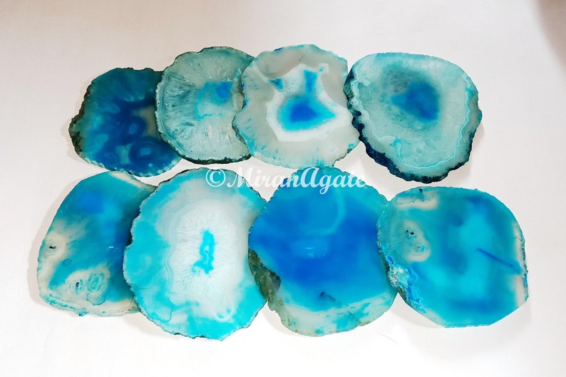 May include: Set of eight agate coasters in shades of blue and white. The coasters are round and have a natural, polished finish.