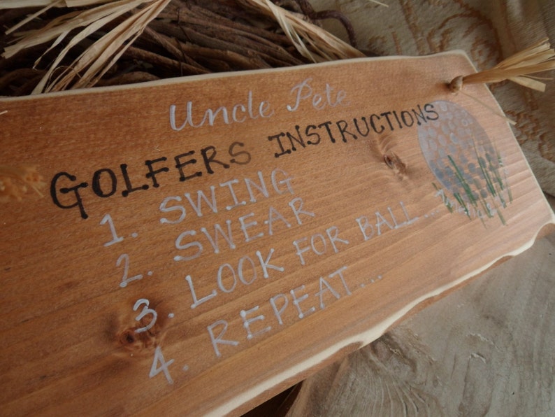 Puede incluir: Un letrero de madera con el texto "Uncle Pete Golfers Instructions" y una lista de instrucciones: "1. Swing 2. Swear 3. Look for ball 4. Repeat..."