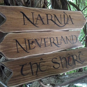 May include: Three wooden arrow signs with the words "Narnia", "Neverland", and "The Shore" written in black lettering.
