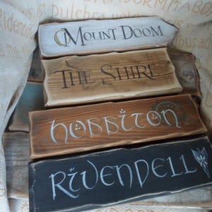 Pu&ograve; includere: Quattro cartelli in legno con diverse localit&agrave; fantasy scritte su di essi. I cartelli sono Monte Fato, La Contea, Hobbiton e Gran Burrone.
