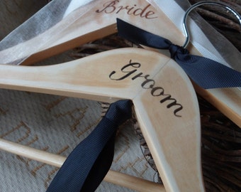 Bespoke wedding hangers... a pair of his and hers wedding hangers with hand painted Bride and Groom. Finished with Grosgrain Bow Ties.