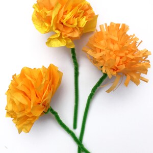 K&ouml;nnte beinhalten: Drei gelbe Papierblumen mit gr&uuml;nen Pfeifenputzer-Stielen. Die Blumen sind aus Seidenpapier gefertigt und haben eine gekr&auml;uselte Optik.