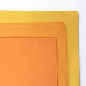 K&ouml;nnte beinhalten: Drei Bl&auml;tter Papier in verschiedenen Oranget&ouml;nen und Gelb. Das oberste Blatt ist gelb, das mittlere Blatt ist hellorange und das unterste Blatt ist dunkelorange.