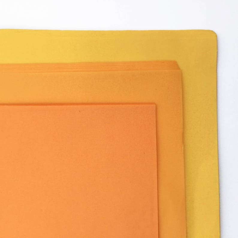 K&ouml;nnte beinhalten: Drei Bl&auml;tter Papier in verschiedenen Oranget&ouml;nen und Gelb. Das oberste Blatt ist gelb, das mittlere Blatt ist hellorange und das unterste Blatt ist dunkelorange.