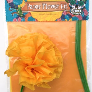 K&ouml;nnte beinhalten: Ein Papierblumen-Set mit einer gelben Papierblume, gr&uuml;nen Pfeifenreinigern und einem leuchtend orangenen Hintergrund. Die Verpackung lautet "Ex-Voto Design Paper Flower Kit (Makes 3 Large Flowers)"