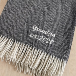 Peut inclure: Une couverture en laine gris et blanc à motif chevron avec une inscription brodée blanche qui dit "Grandpa est 2020".