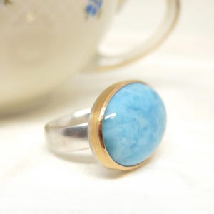 Larimar ring in silver with 18K rose gold, featuring a large light blue oval gemstone cabochon; a handmade, one-of-a-kind piece for women