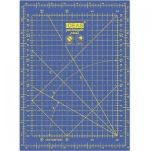 Könnte beinhalten: Blaue, selbstheilende Schneidematte mit einem Rastermuster und Linealmarkierungen in Zentimetern. Die Matte trägt den Text "IDEAS patchwork" und ein Logo mit einem Kreis und einer Schere.