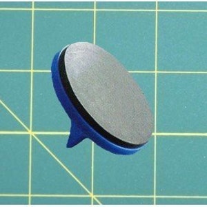 Puede incluir: Una peonza azul y negra con una punta puntiaguda y una base plana y redonda.