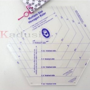 Op de afbeelding: Duidelijke, zeshoekige kunststof liniaal met markeringen om zeshoeken van verschillende groottes te maken. De liniaal heeft inch-markeringen voor afgewerkte zijden van 1 1/4 inch tot 4 inch.