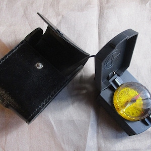 Une belle boussole vintage en étui en cuir, fabriquée en France