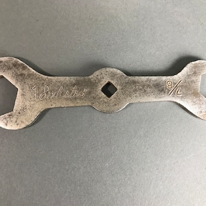 May include: A silver wrench with a 1 1/8 inch and 8/16 inch opening. The wrench is labeled "Embistro".