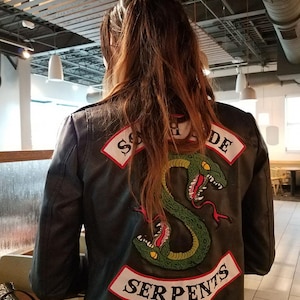 May include: Black leather jacket with a green snake and "Southside Serpents" embroidered on the back.