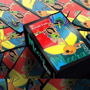 May include: A box of Meera Tarot cards by Runali Patil. The box is black with a green and blue design. The front of the box features a colourful illustration of two figures playing music. The text on the box reads "Meera Tarot" and "By Runali Patil".