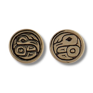 Può includere: Un paio di orecchini dorati con un design nero di un uccello stilizzato. Gli orecchini sono rotondi e hanno una superficie liscia.