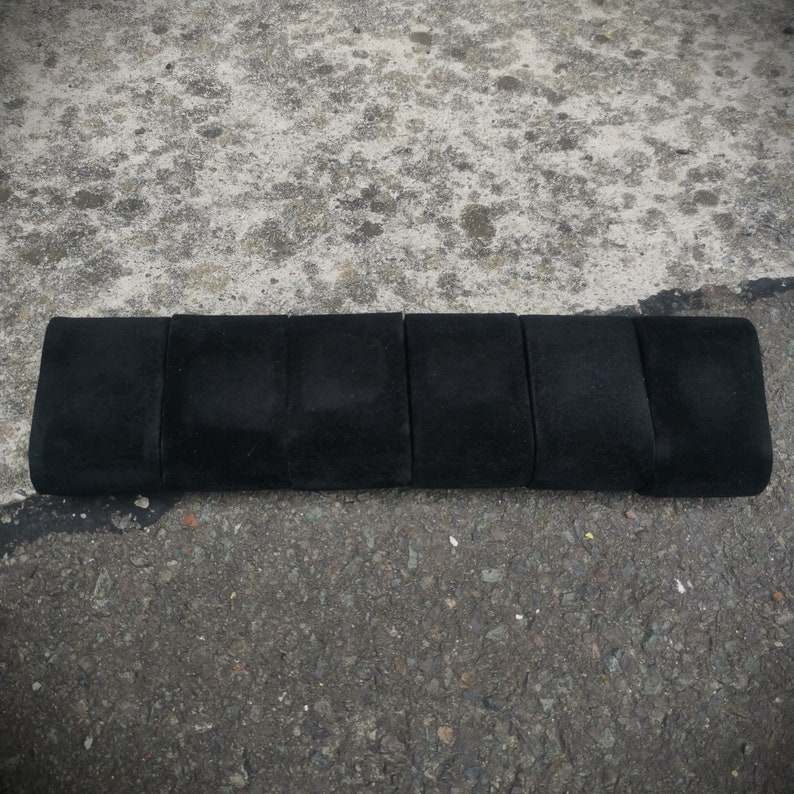 K&ouml;nnte beinhalten: Sechs rechteckige Boxen mit schwarzem Samtbezug in einer Reihe angeordnet.