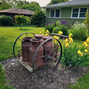 Antique metal wheels with 4 large Antique cans