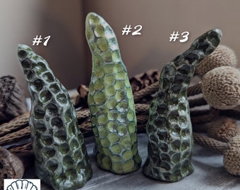 Puede incluir: Tres esculturas de cerámica verde con un patrón de panal. Las esculturas están numeradas del 1 al 3.