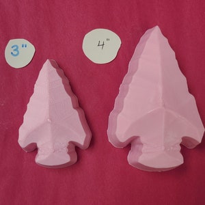 May include: Two pink arrowhead-shaped silicone molds, one measuring 3 inches and the other measuring 4 inches.