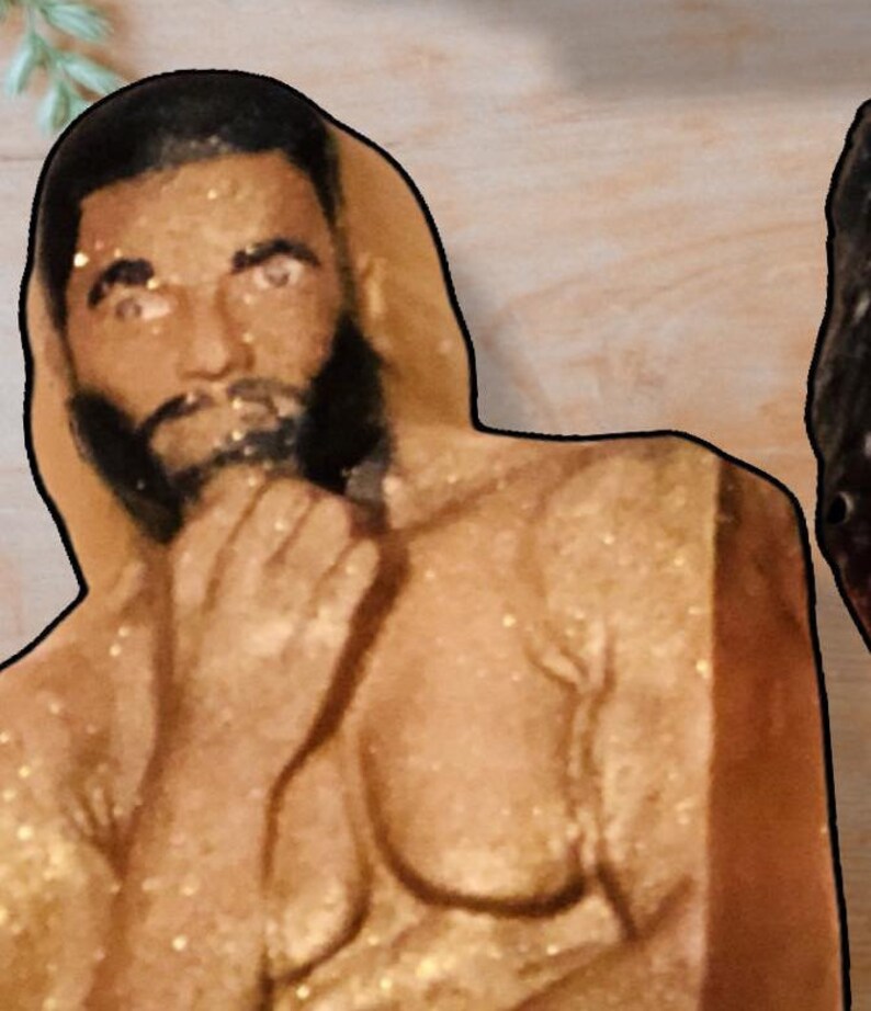 Puede incluir: Un primer plano del torso de una persona, cubierto de purpurina dorada. La persona mira a la c&aacute;mara con una expresi&oacute;n seria. Su cabello es negro y tiene barba.