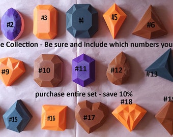 Puede incluir: Una colección de 19 moldes de resina con forma de gemas de colores. Los moldes están numerados del 1 al 19. El texto "Gemstone Collection - Be sure and include which numbers you want" está escrito debajo de la primera fila de moldes. El texto "purchase entire set - save 10%" está escrito debajo de la segunda fila de moldes.