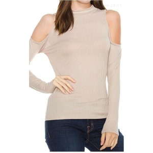 May include: A beige ribbed long-sleeve shirt with a mock neck and cold shoulder cutouts.