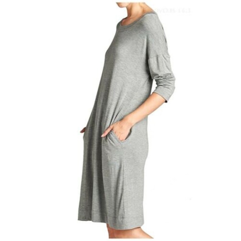 Puede incluir: Un vestido midi gris de manga larga con cuello redondo y dos bolsillos. El vestido est&aacute; hecho de una tela suave y c&oacute;moda.