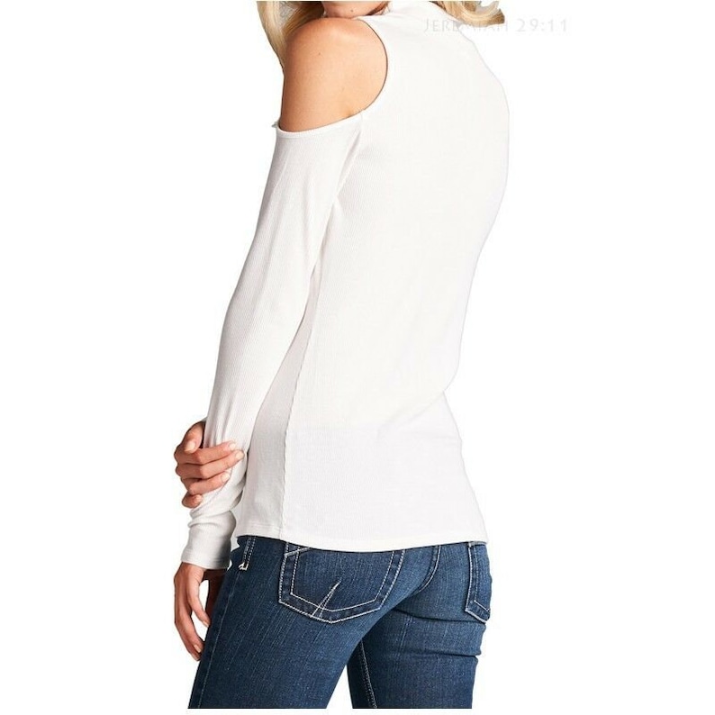 May include: White long-sleeve shirt with a cold shoulder design and a mock neck. The shirt is made of a ribbed fabric.