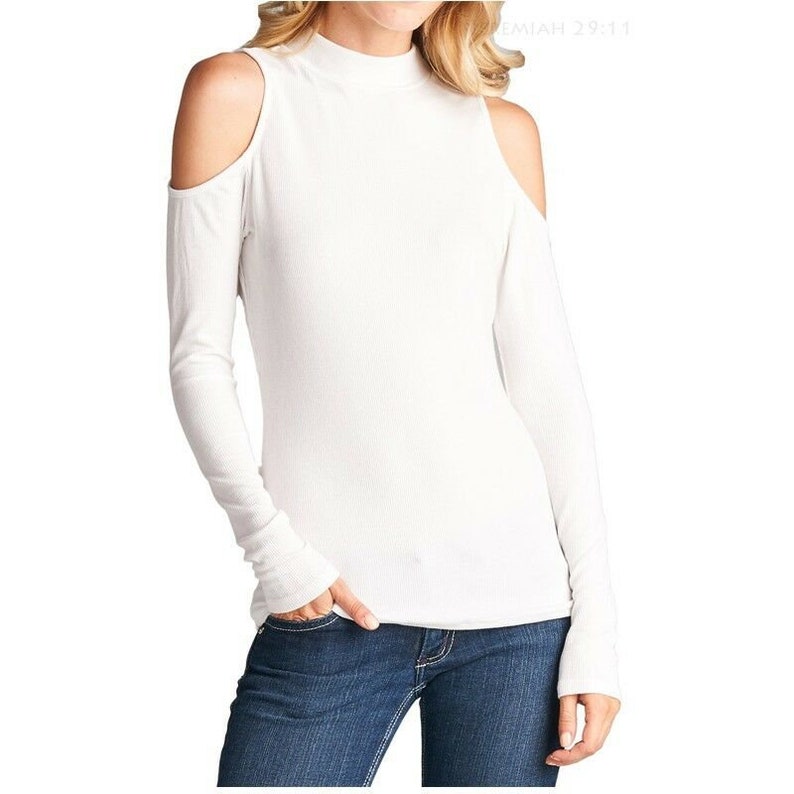 May include: White long-sleeve shirt with a mock neck and cold shoulder cutouts. The shirt has a ribbed texture.