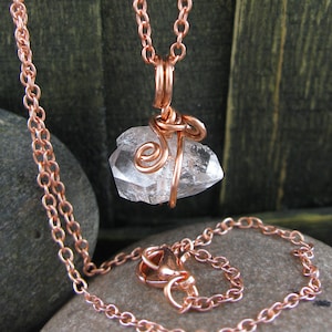 以下が含まれることがあります： 銅製のチェーンネックレスに、銅線で包まれた透明な水晶のペンダントがついたもの