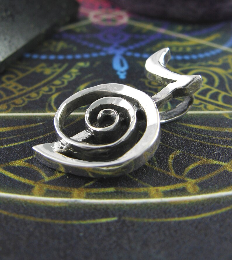 May include: A silver pendant featuring a double spiral design. The spiral is a symbol of growth, transformation, and the interconnectedness of all things.