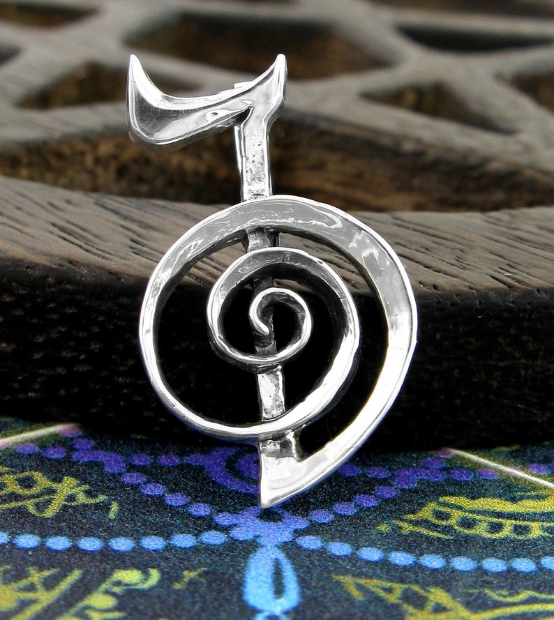 May include: Silver pendant featuring a stylized spiral symbol, often associated with growth and transformation.