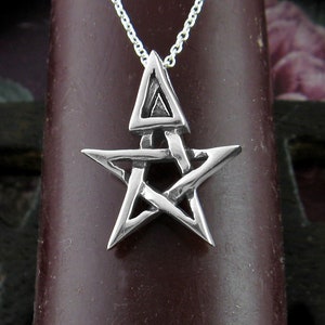 May include: A silver pendant necklace featuring a five-pointed star with a triangle inside. The star is intricately designed with a woven pattern.