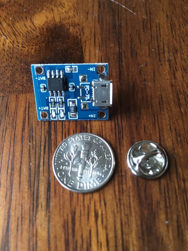 May include: A small blue circuit board with a micro USB connector and the text "FC-75" printed on it. The board is about the size of a UK ten pence coin.