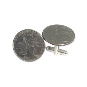 May include: Silver cufflinks featuring a 2001 New York State quarter with the Statue of Liberty and the text "New York 1788 Gateway to Freedom" on the front.