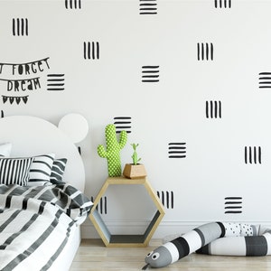 May include: A white bed with a black and white striped duvet and pillows. The wall behind the bed is white with black lines forming a geometric pattern. The text "Don't forget to dream" is written on the wall in black.