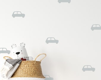 Peut inclure: Un ours en peluche blanc avec un cœur rouge sur la poitrine est assis dans un panier en osier. Le mur derrière l'ours est blanc avec un motif de voitures grises.