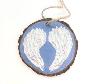 WOOD WINGS ORNAMENT - 2.5" Christmas Ornament on a Wood Tree Slice with White and Silver Wings on a Blue Background