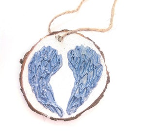 WOOD WINGS ORNAMENT - 2.5" Christmas Ornament on a Wood Tree Slice with Blue and Silver Wings on a White Background