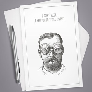 May include: A black and white illustration of a man wearing goggles. The text "I don't sleep. I keep other people awake." is printed above the illustration.