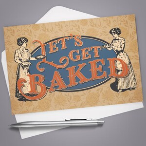 May include: Greeting card with the text "LET'S GET BAKED" in orange letters on a blue oval. The card features illustrations of women in aprons holding baked goods, set against a floral background. A silver pen rests on the white envelope.