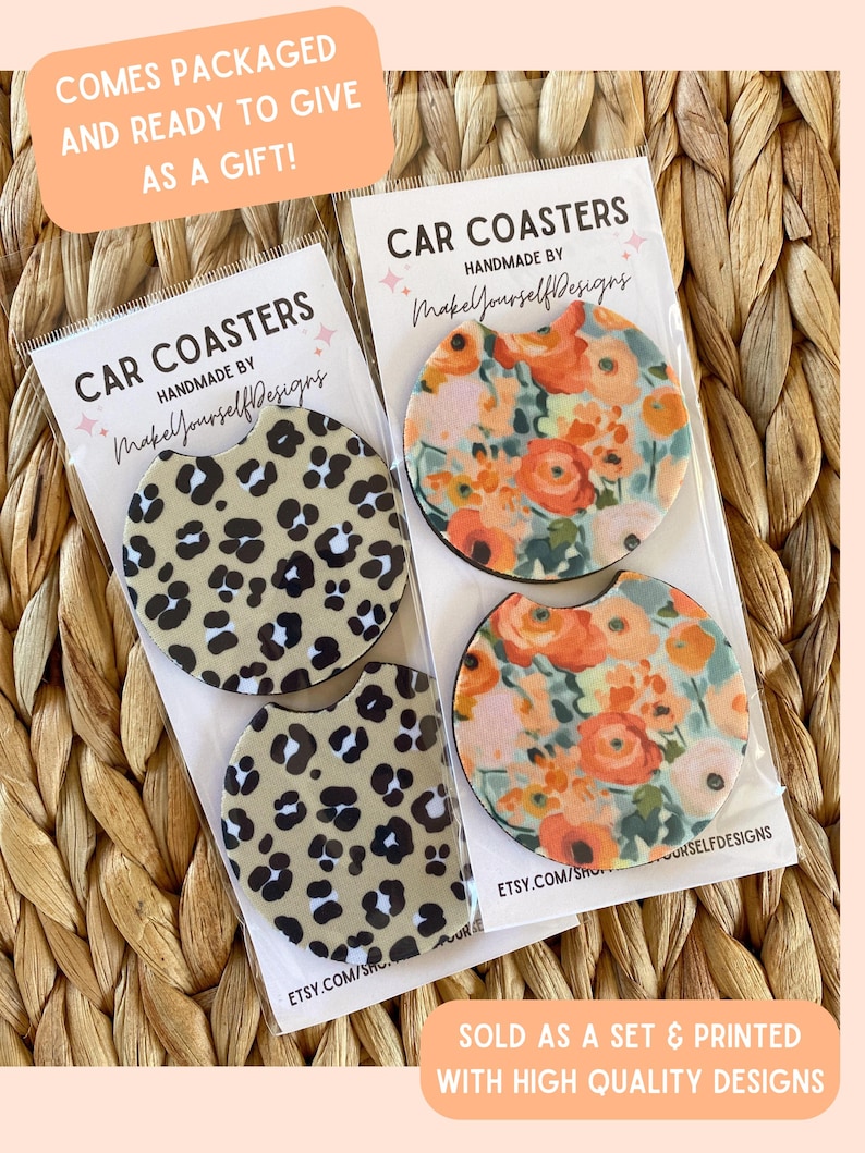 May include: Two sets of car coasters are displayed, each packaged in clear plastic. One set features a leopard print design, while the other showcases a floral pattern with orange and pink flowers. Text on the packaging reads "Car Coasters" and "Handmade by MakeYourselfDesigns."