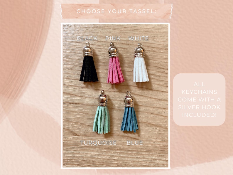May include: A selection of keychains with different colored tassels: black, pink, white, turquoise, and blue. Each tassel has a silver-colored cap. The text "CHOOSE YOUR TASSEL" is at the top. The text "ALL KEYCHAINS COME WITH A SILVER HOOK INCLUDED!" is on the right.