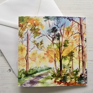 May include: Watercolor painting of a forest path with trees in autumn colors. The path winds through the trees, with leaves in shades of yellow, orange, and red.